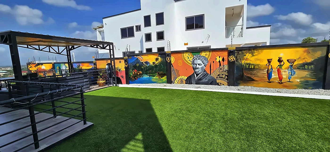 Rooftop terrace with murals along the wall and the neighboring building