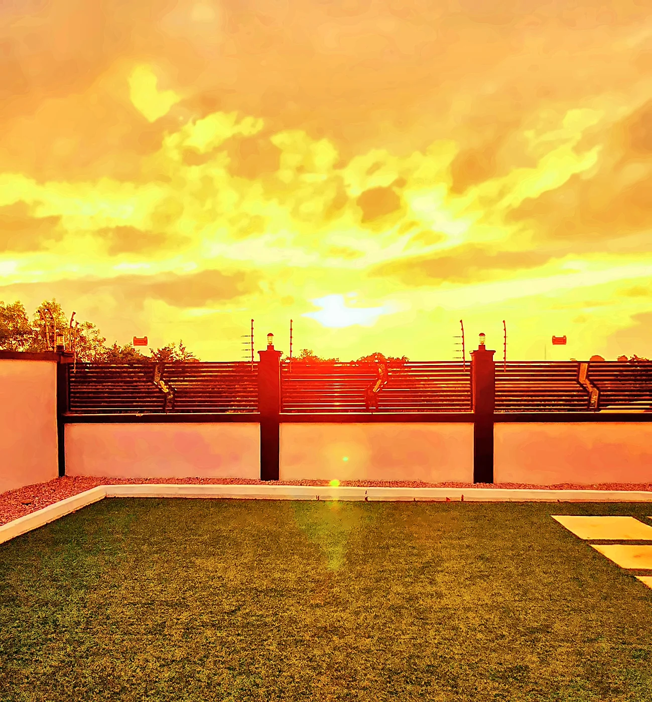 Golden sunset sky over the center's lawn and garden wall